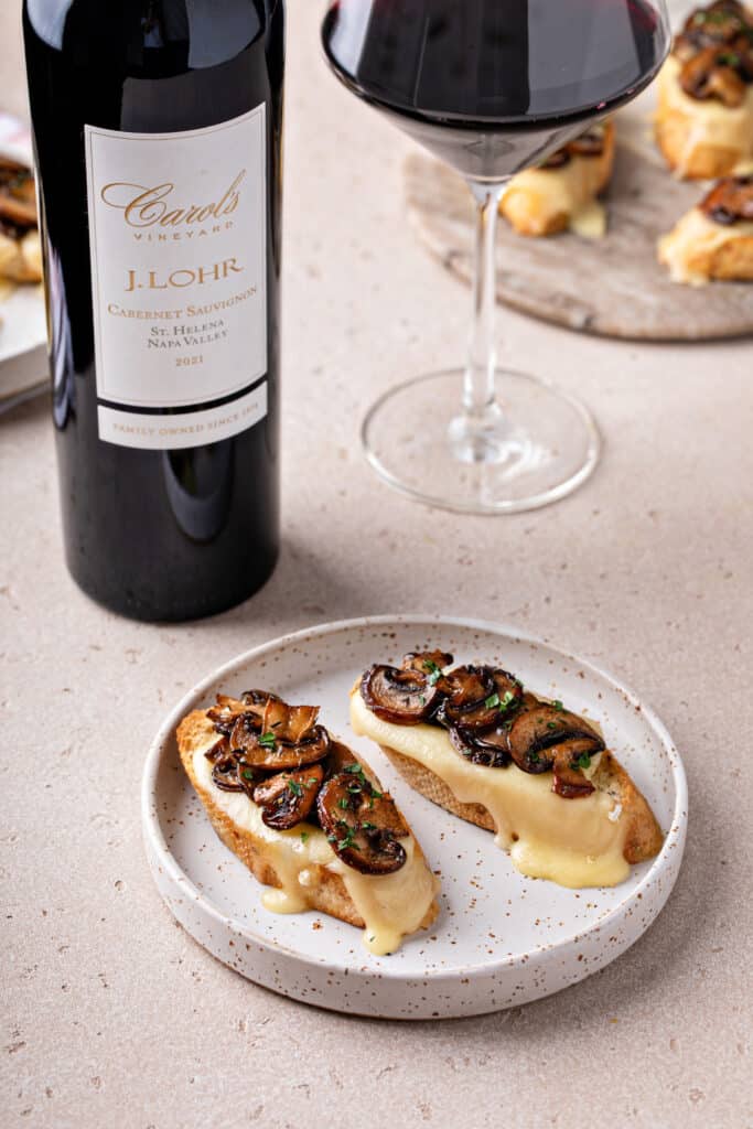 mushroom brie crostini with wine glass