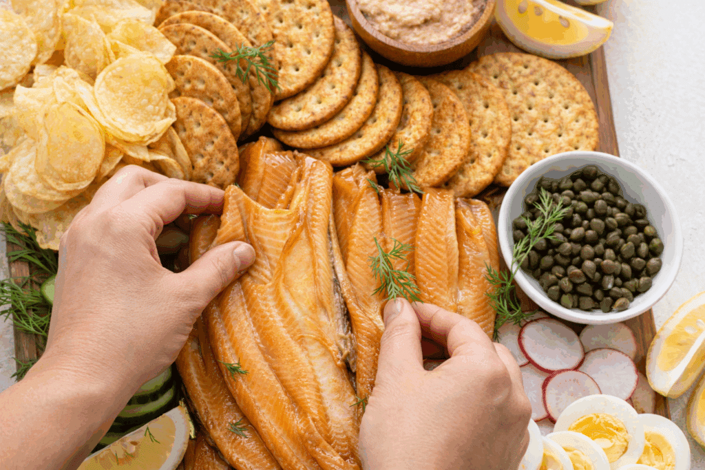 woman arranging soked trout in a board