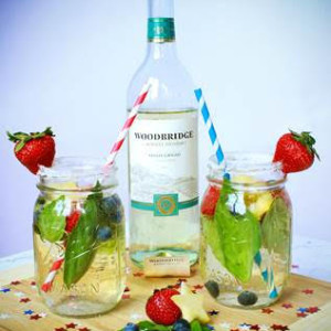 Two mason jars of white wine sangria with strawberries and mint