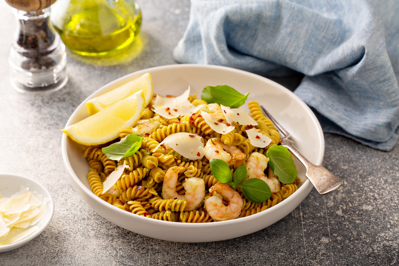 pesto basil shrimp with chickpea pasta in a white bowl for weeknight dinner image