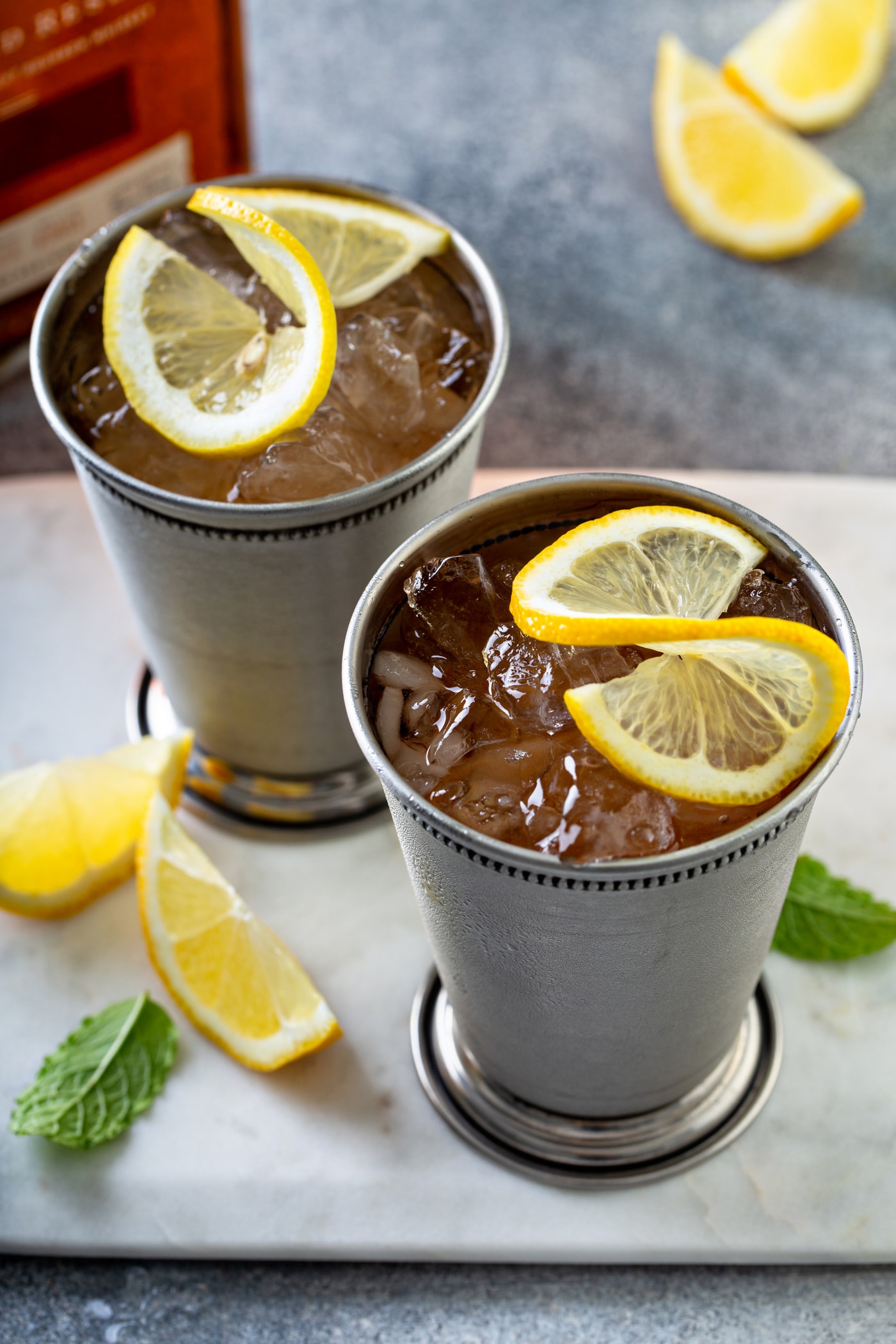 Two Woodford Spire cocktails in silver cups with lemon and mint