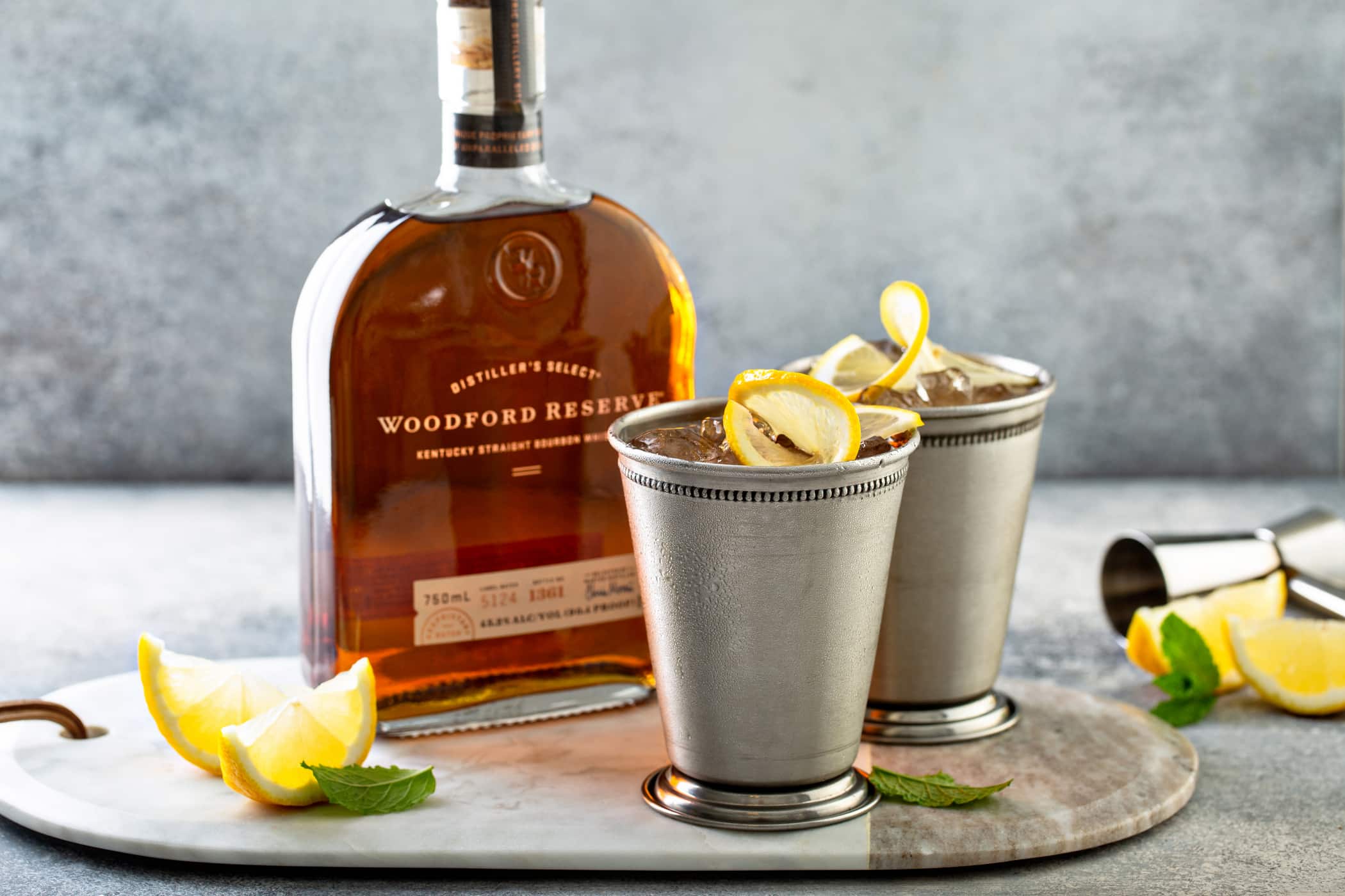 Woodford Reserve bottle with two Woodford Spire cocktails in silver cups