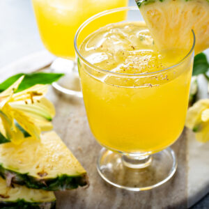 Leia pineapple cocktail with a pineapple wedge and tropical leaves