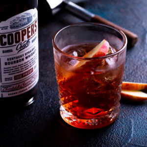 Cooper's Craft bourbon bottle beside an Imperial Boulevardier with orange