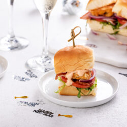 Catfish BLT sliders on a New Years table with champagne flutes and confetti