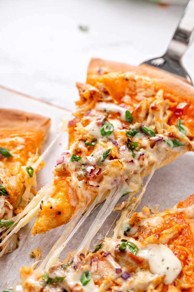 This Buffalo Chicken Pizza is super easy to make with blue cheese or ranch; topped with delicious toppings like buffalo chicken, cilantro, red onions, and more. Trust the whole family will love this recipe!