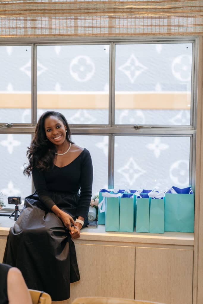 Erica A. Thomas seated beside Friendsgiving gift bags at The Blue Box Café in New York