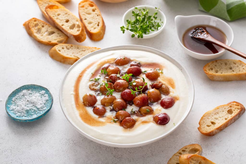 Whipped Ricotta with Roasted Grapes & Hot Honey with white bowl