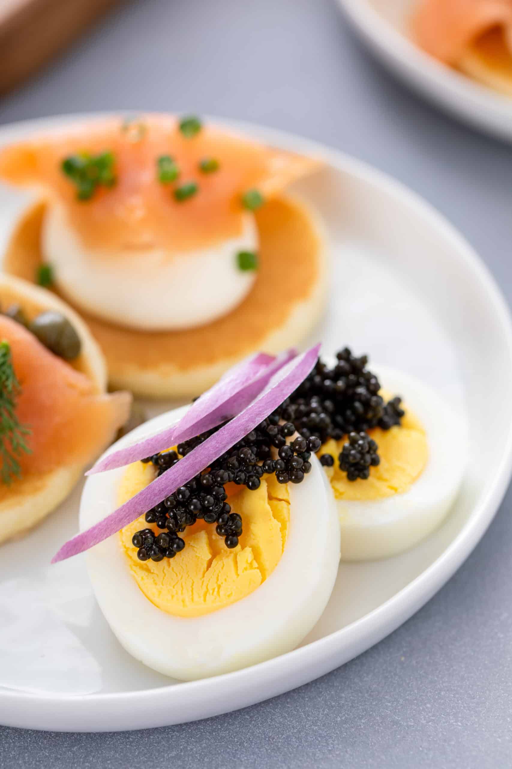 Close-up of blini with black caviar, smoked salmon and slivers of red onion