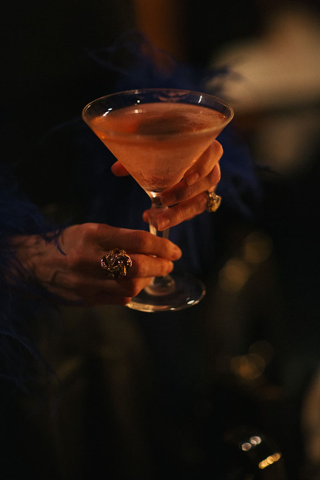 A guest holding a pink champagne cocktail at the Galentine's dinner table
