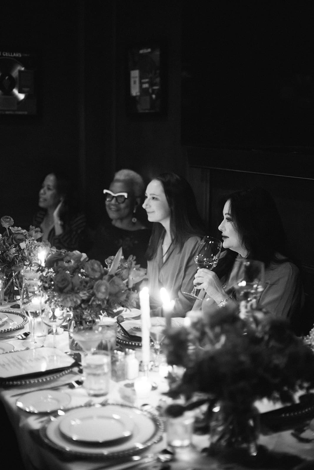 Guests listening intently to a toast during the Galentine's dinner at Hal's