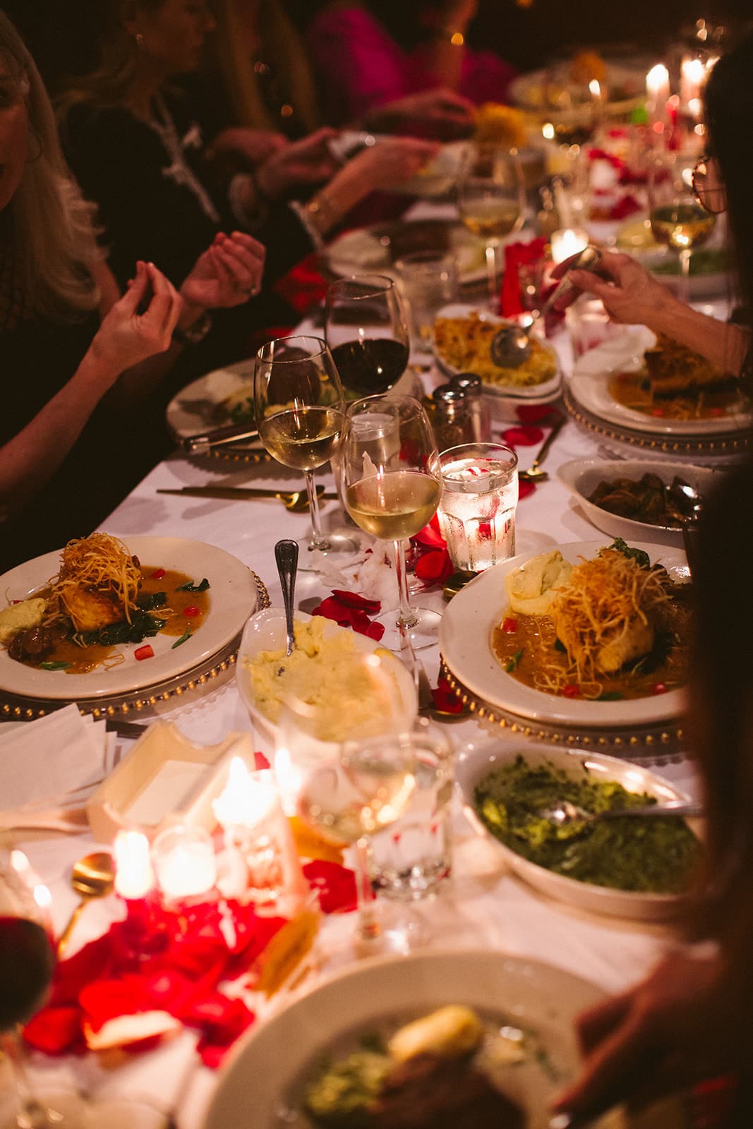 Guests passing family-style side dishes down the candlelit table at Hal's Steakhouse