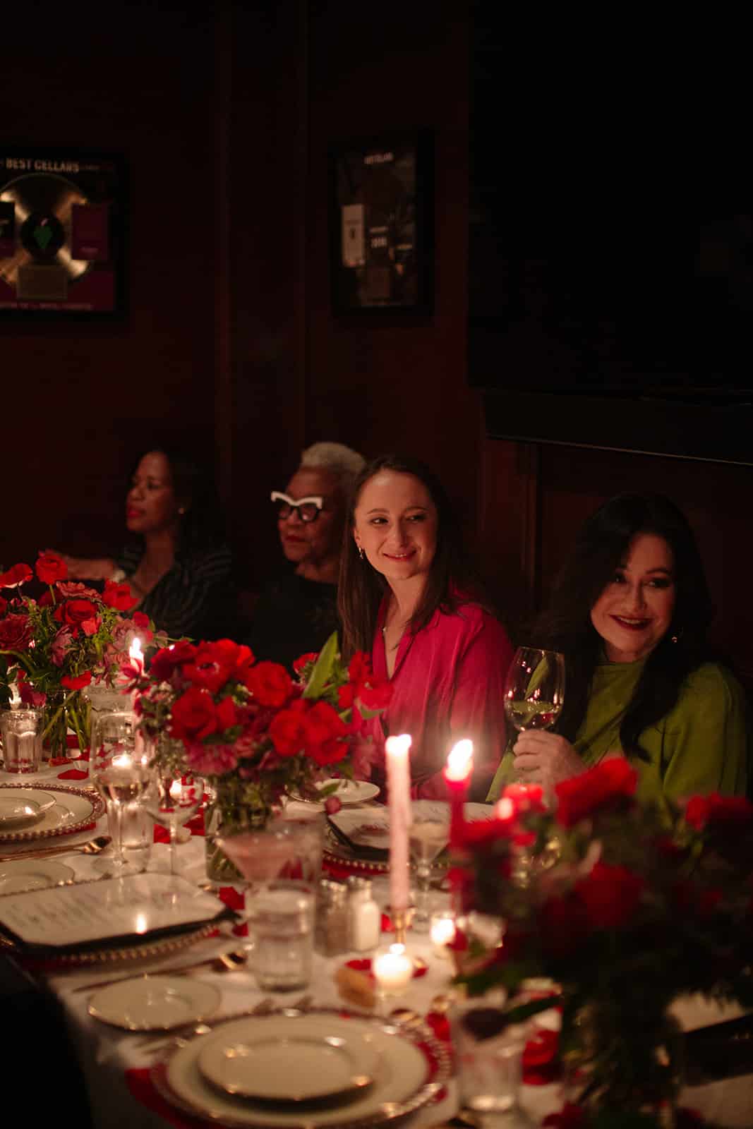 Guests smiling and laughing together at the rose-covered Galentine's table