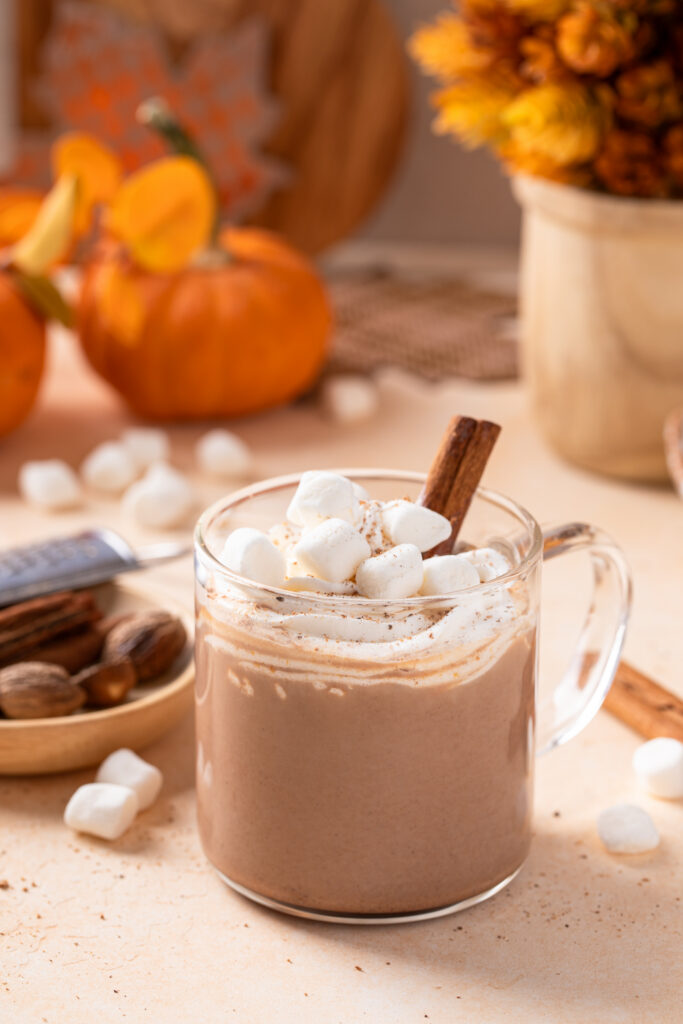 Cozy fall pumpkin hot chocolate served in a mug on a sweater-weather table
