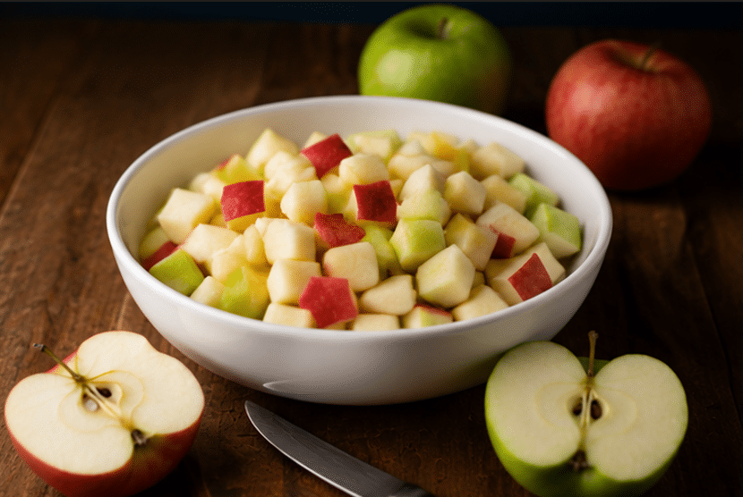 Easy Fall Apple Pie Sangria Cocktail chopped apples on a white bowl with two whole and halves apples