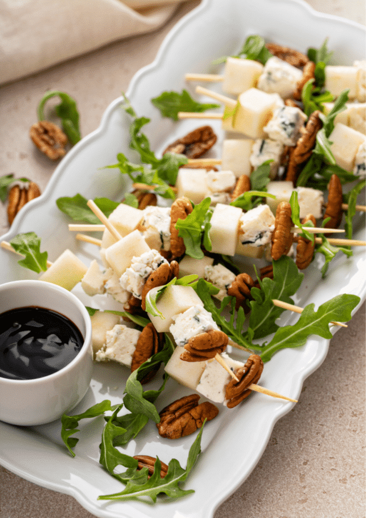 close up shot on the serving platter Pear and Bleu Cheese Appetizer Skewers with Arugula and Pecans