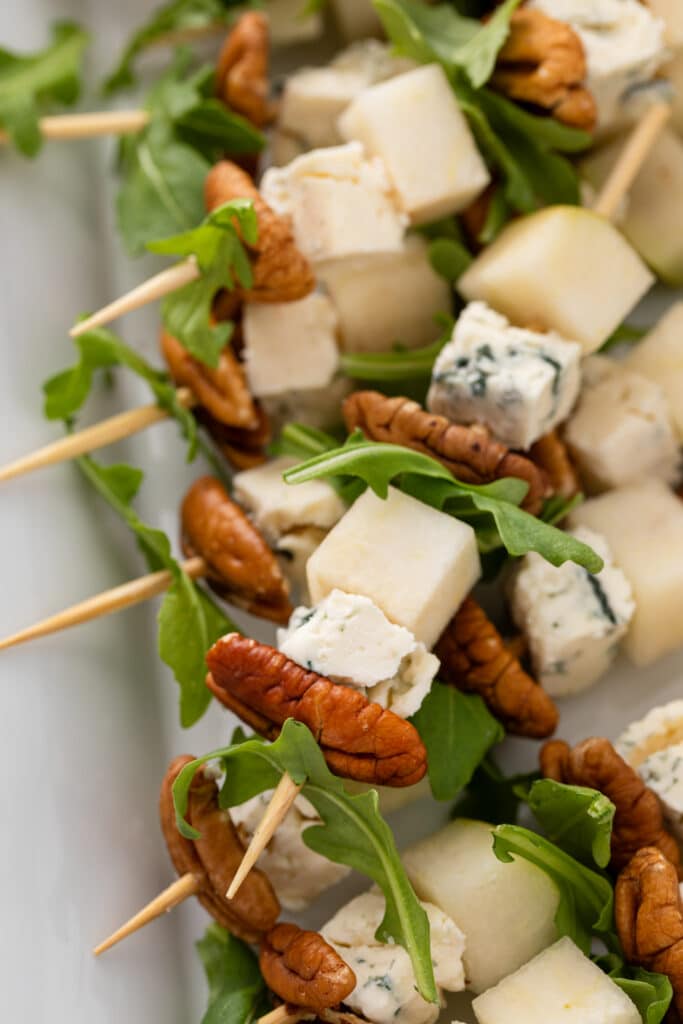 Side shot of Pear and Bleu Cheese Appetizer Skewers with Arugula and Pecans