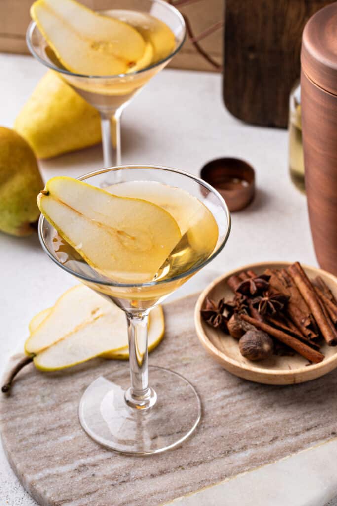 Adding the chilled pear vodka base over ice in a cocktail shaker