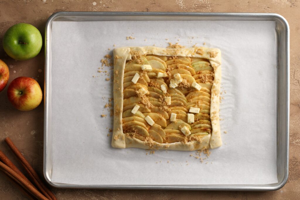 Overhead of arranged cinnamon apple slices on puff pastry before baking