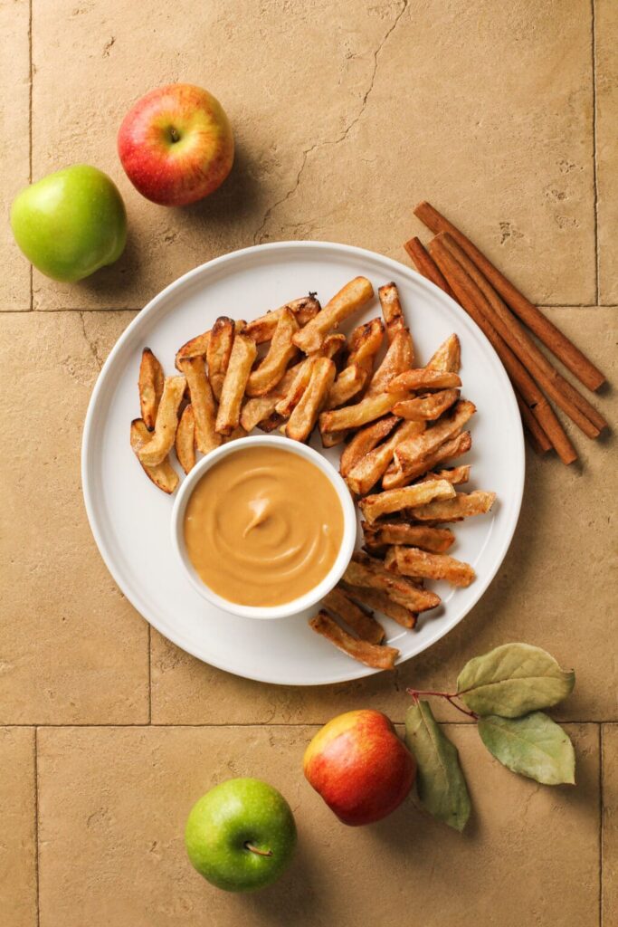 Air Fryer Apple Fries with Caramel Cream Dip shot from above with cinnamon sticks and apples as plating