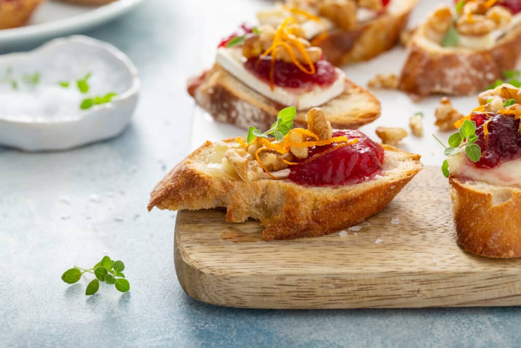 Cranberry brie and walnut crostini arranged on a holiday serving platter