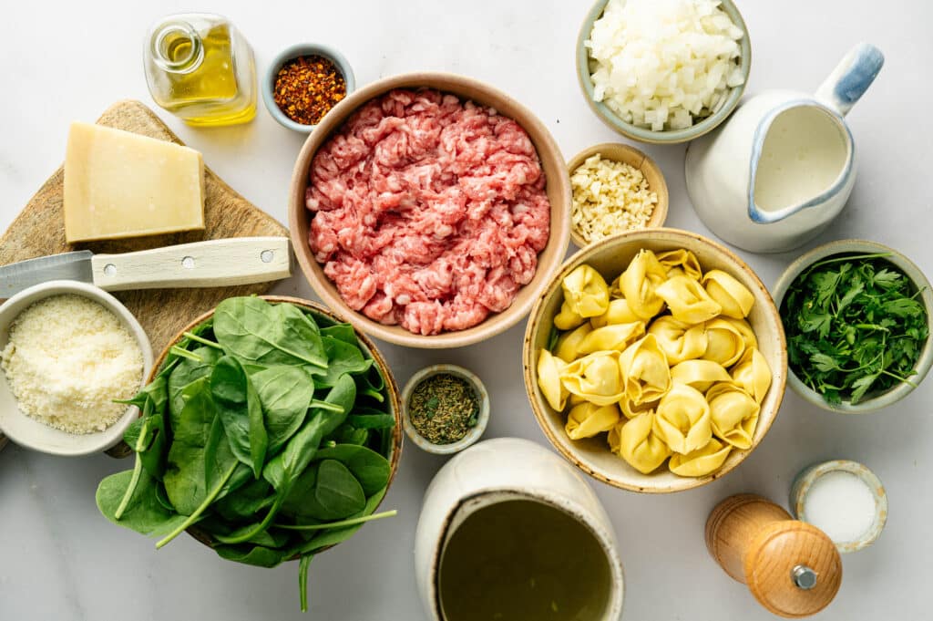 Ingredients for White Sausage Tortellini Soup flat lay shot