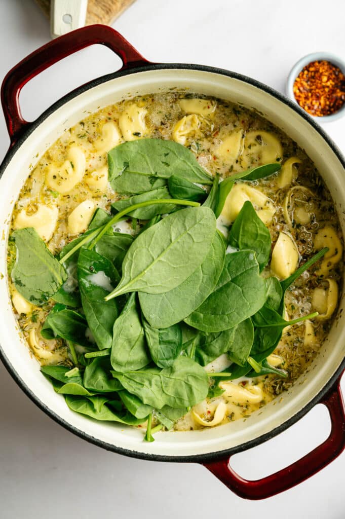 Adding spinach on White Sausage tortellini soup