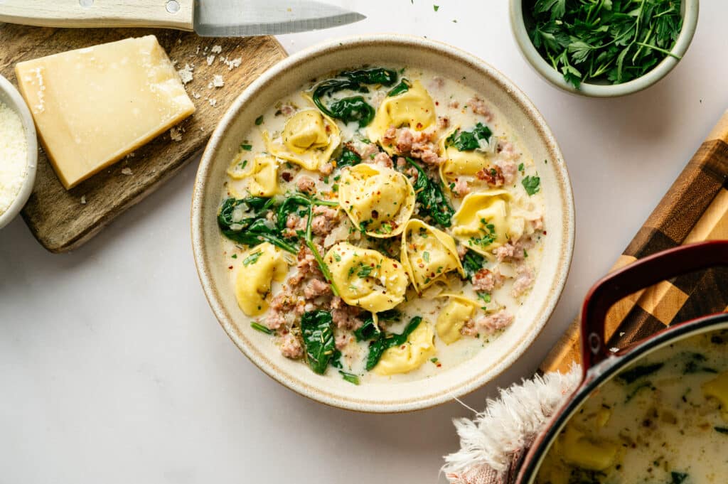 White Sausage tortellini soup shot with cheese and other garnishes