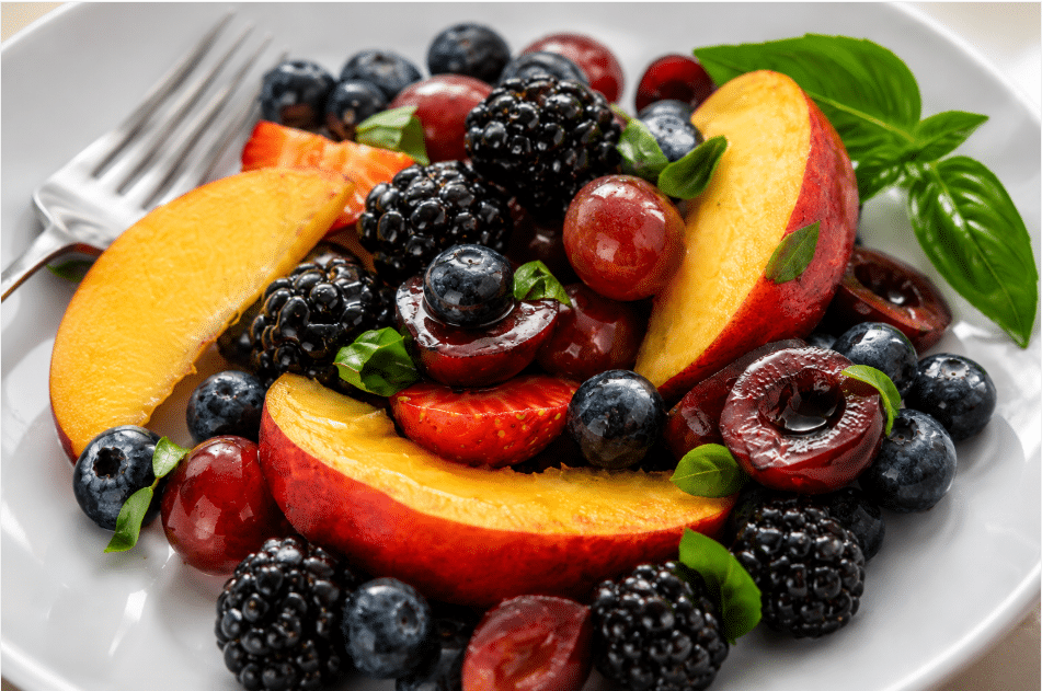 Close up shot of Honey Basil Peach Fruit Salad served in white platter