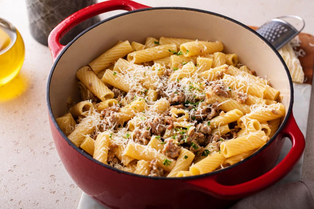 Sausage Rigatoni Pasta served in a pan with cheese and sausage toppings