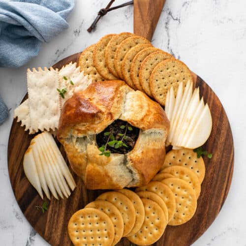 Baked Brie With Balsamic Caramelized Onions served in wooden platter