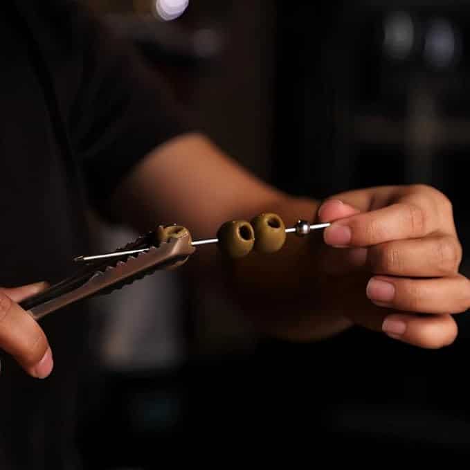 Metal cocktail skewers used to thread pear and bleu cheese skewers with arugula and pecans