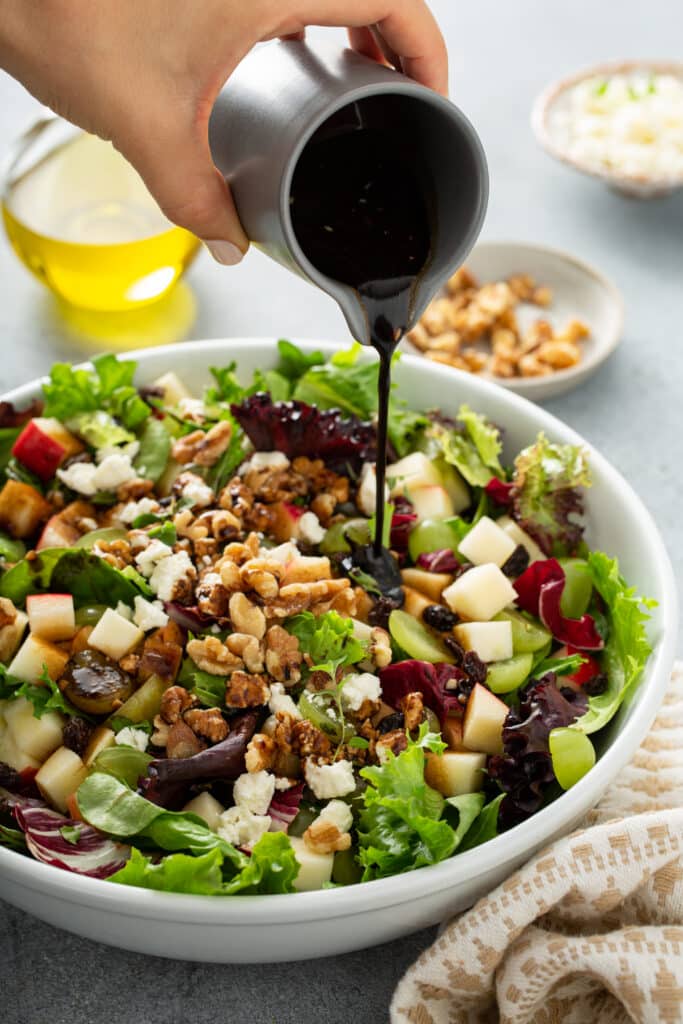 Pouring the dressing to Apple and Goat Cheese Salad