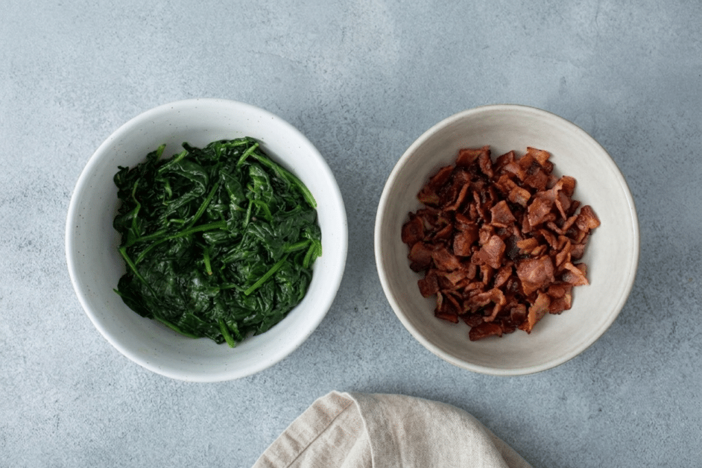 Cooked spinach and bacon for Bacon Spinach & Cheese Egg Muffins