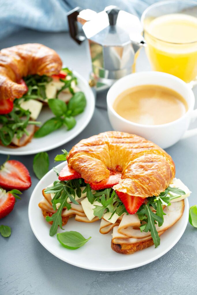 shot together with hot and cold drinks , servings of Turkey Brie Croissant with Strawberries & Basil 