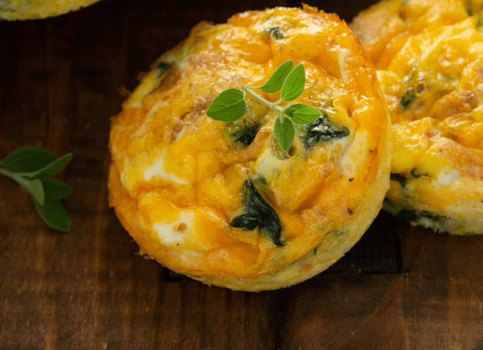 close up shot of Bacon Spinach & Cheese Egg Muffins served in wooden platter