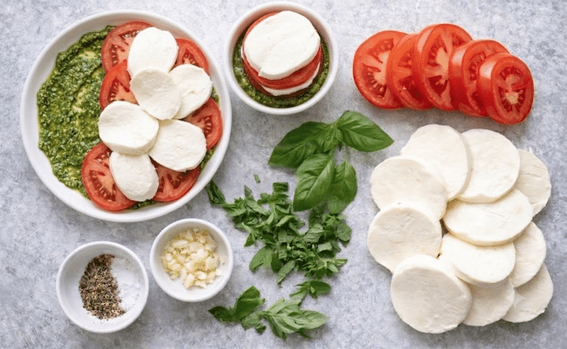 layered tomato, pesto and mozzarella for Basil Pesto Tomato Mozzarella Chicken Bake