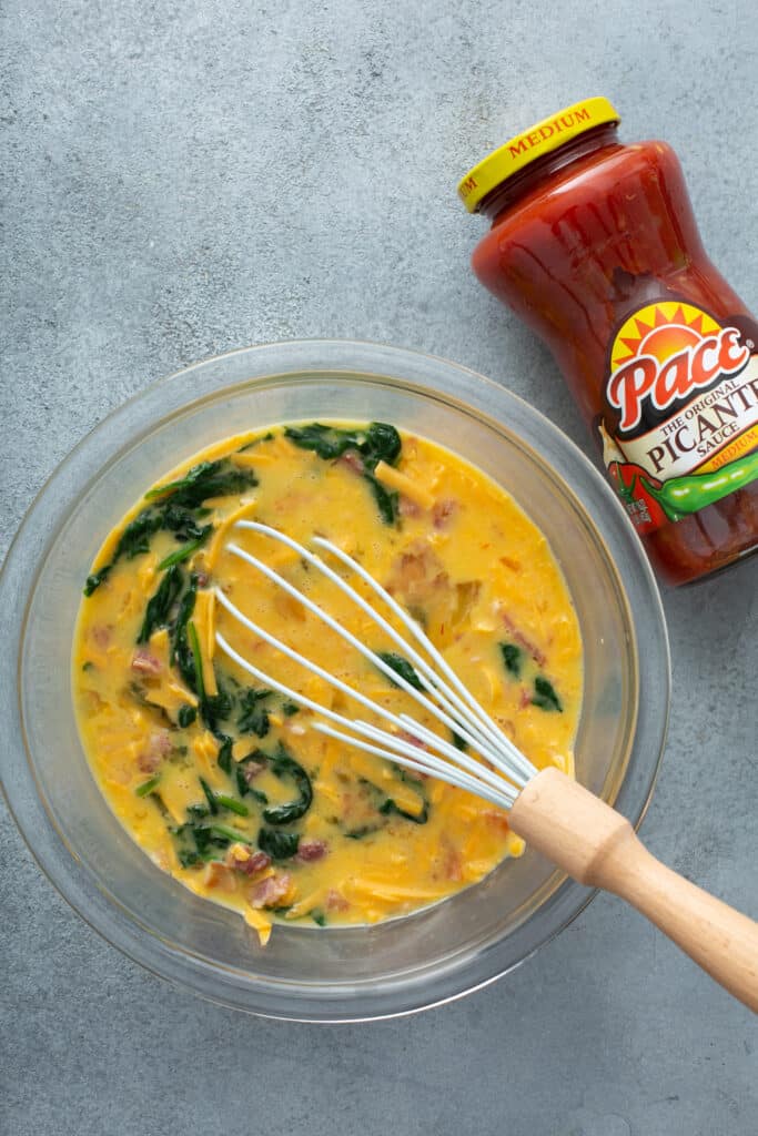 whisk egg mixture for Bacon Spinach & Cheese Egg Muffins