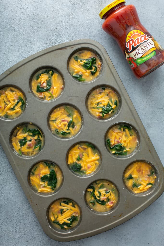 Filled in the muffin pan the mixture for Bacon Spinach & Cheese Egg Muffins