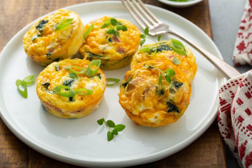 Bacon Spinach & Cheese Egg Muffins served in white platter
