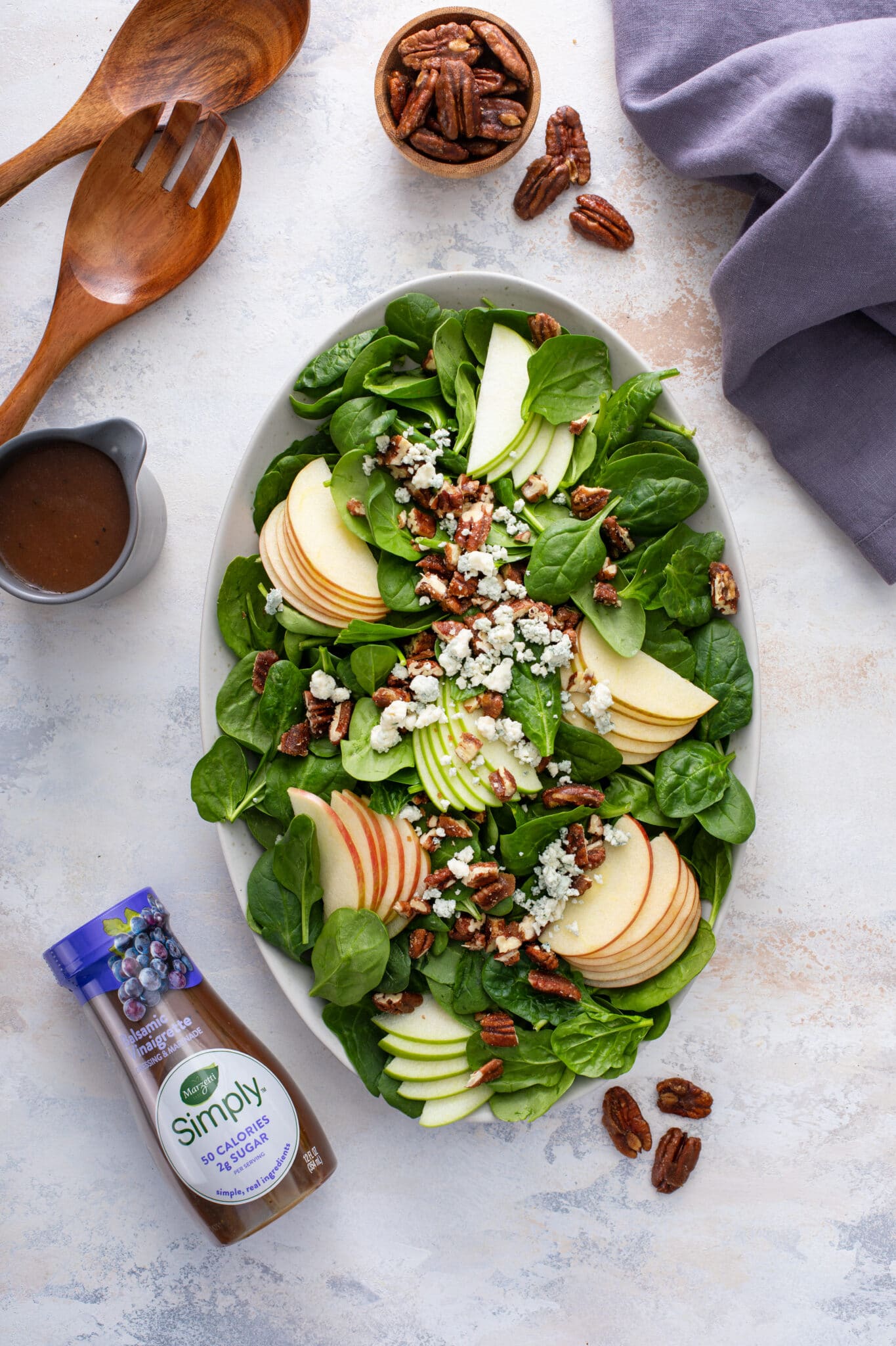 The Perfect Winter Salad served with the store bought dressing, with the pair of wooden spoon and pecans on the side