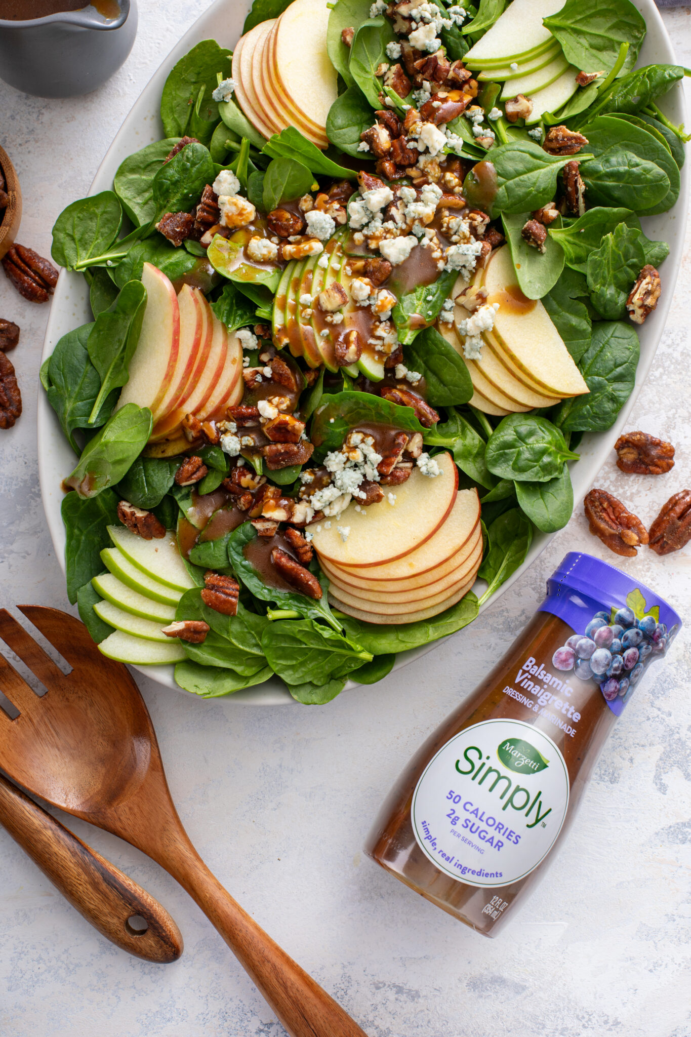 The Perfect Winter Salad served with the store bought dressing, with the pair of wooden spoon and pecans on the side