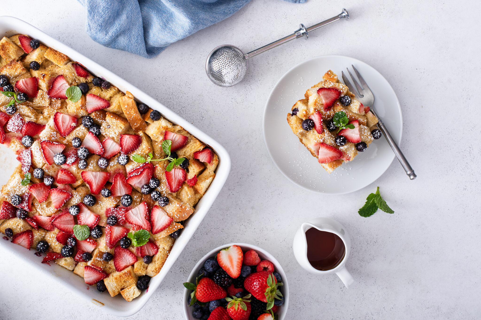 Very Berry French Toast Casserole served from the baking dish topped with powder sugar