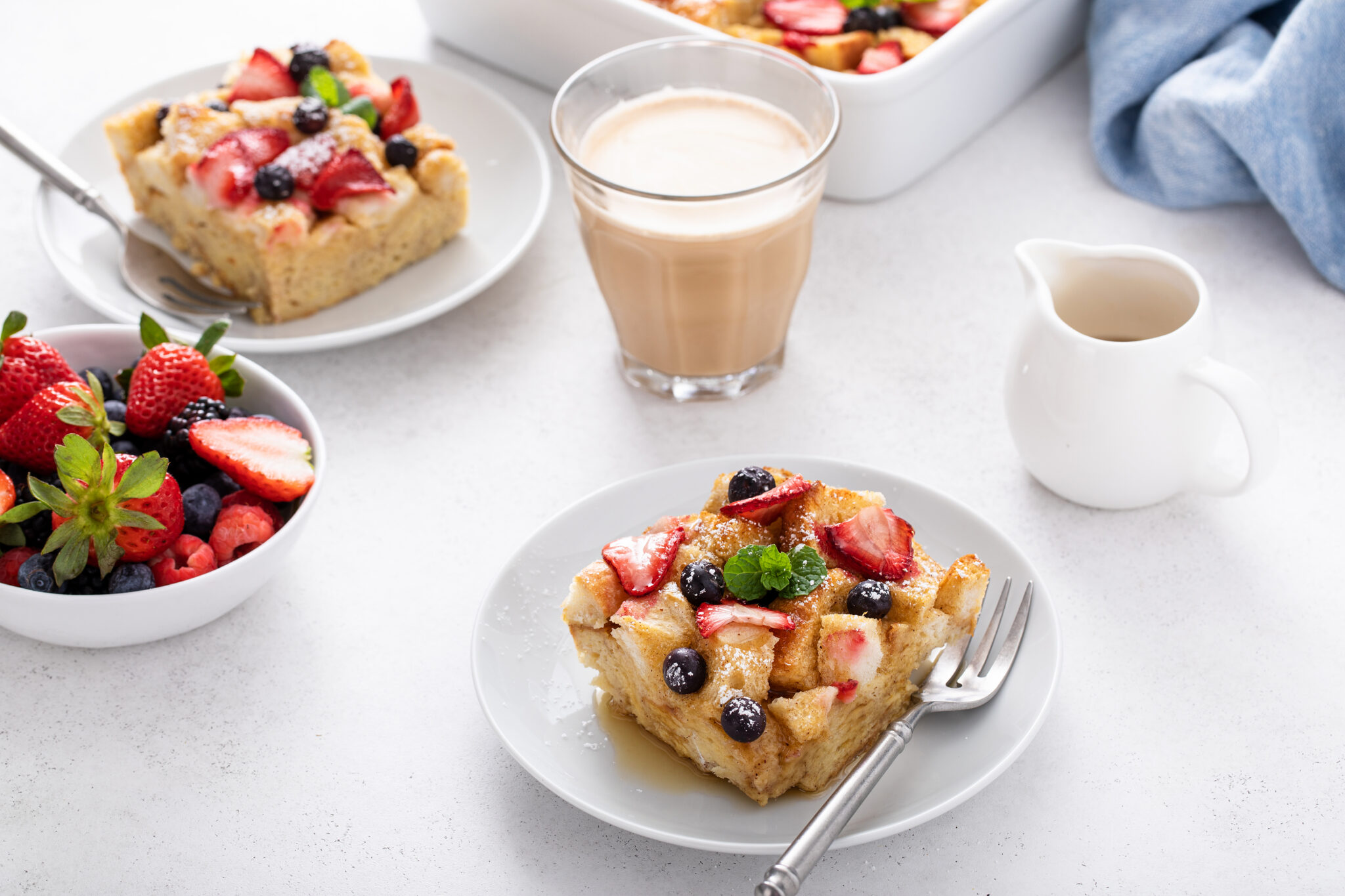 Very Berry French Toast Casserole served with a drink and fresh berries