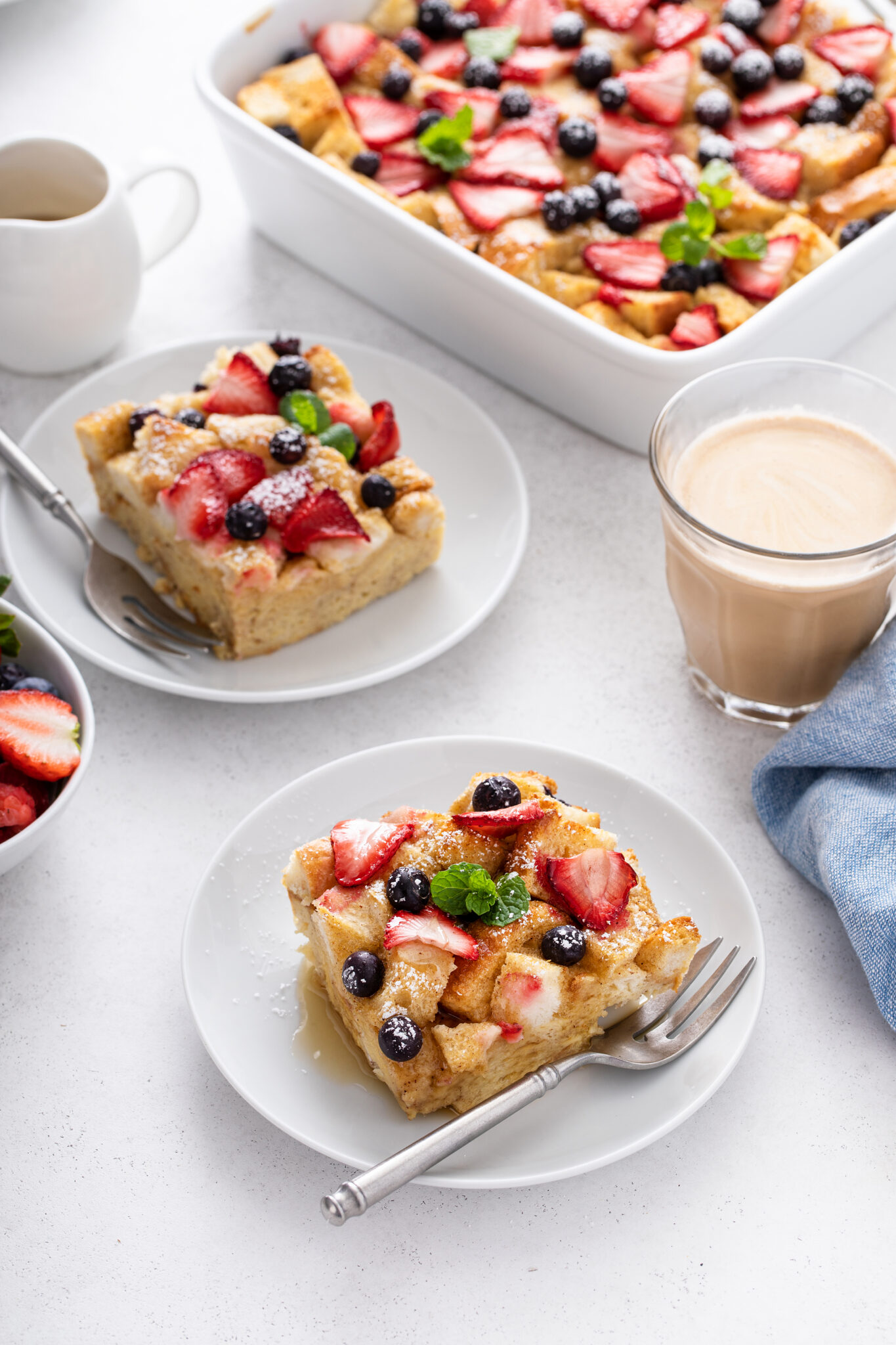 Very Berry French Toast Casserole served with a drink and fresh berries