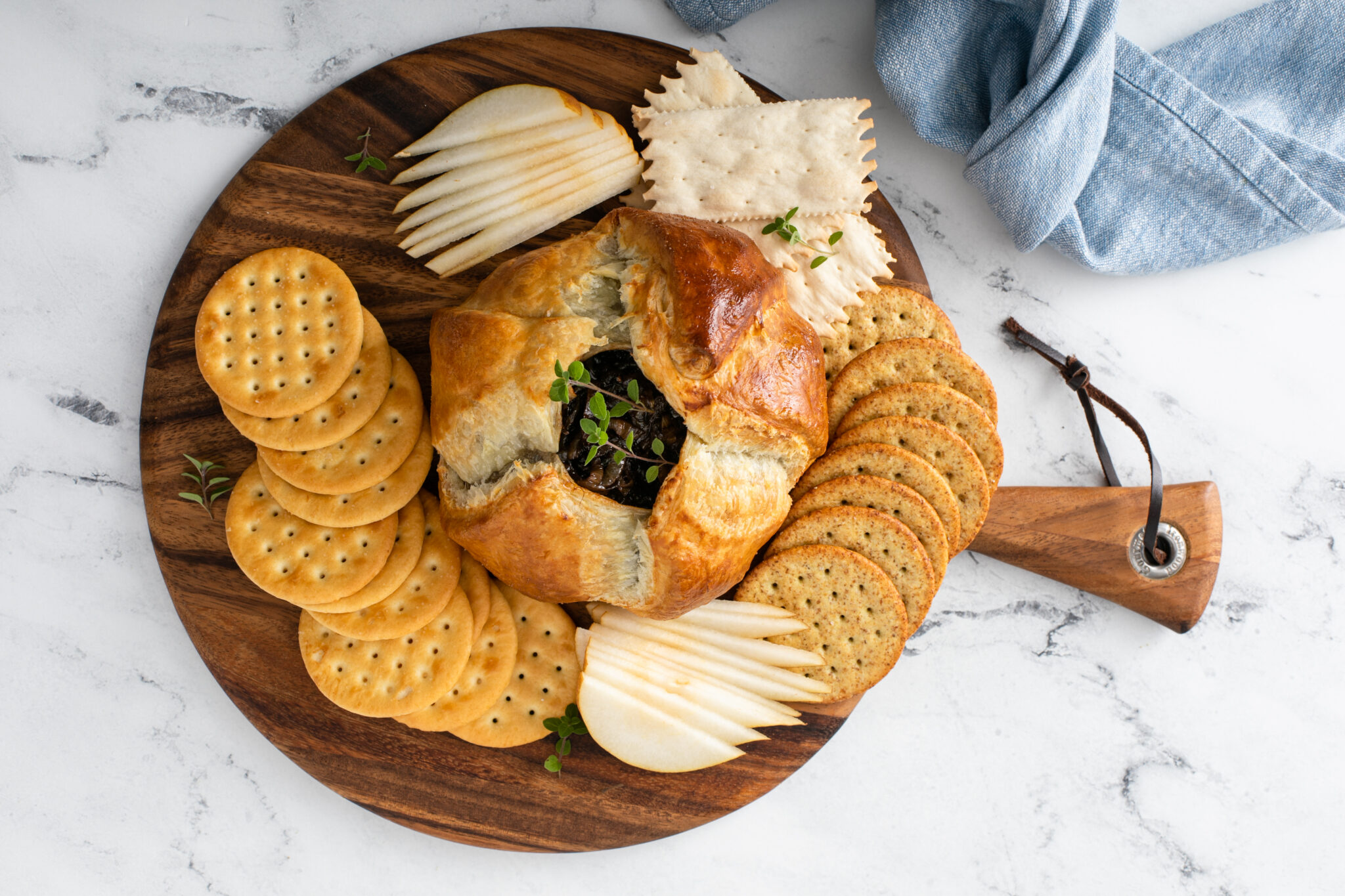 Baked Brie With Balsamic Caramelized Onions served in wooden platter
