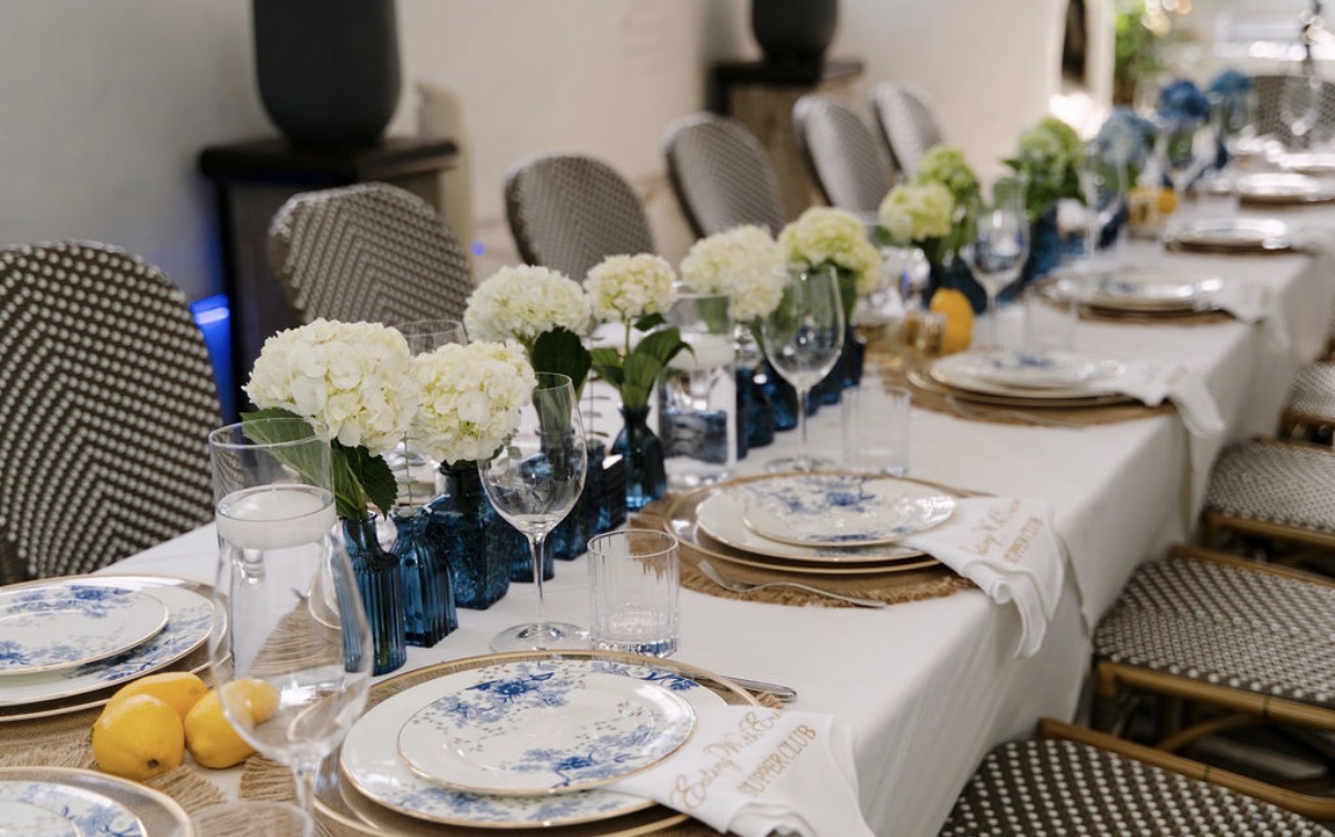 Greek-inspired dinner party table with white hydrangeas in blue glass vases, lemons, floating candles and Lenox Garden Grove china
