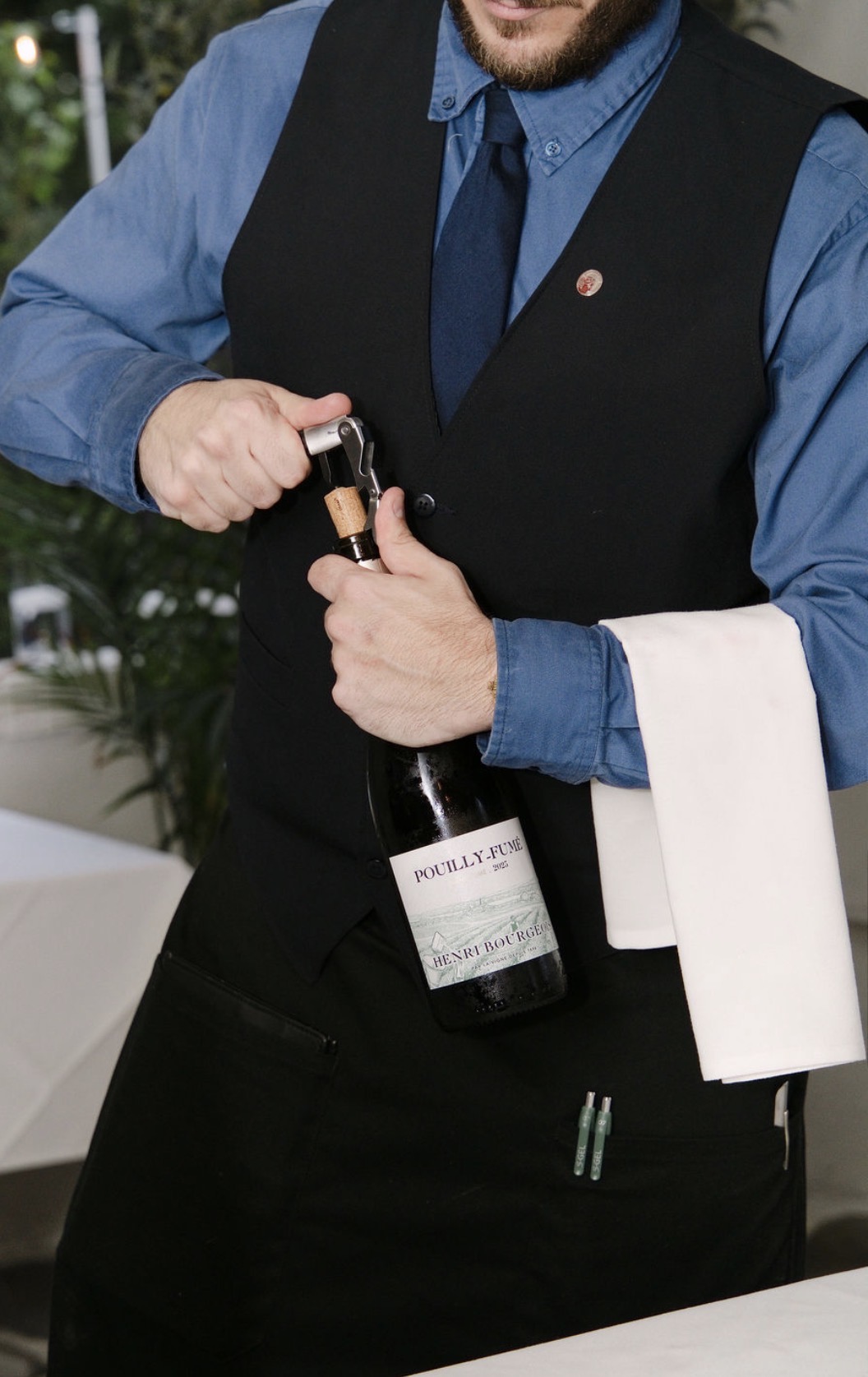 A Kyma server opening a bottle of Henri Bourgeois 2025 Pouilly-FumƩ