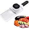 A white handheld mandoline slicer with thinly sliced vegetables beside it
