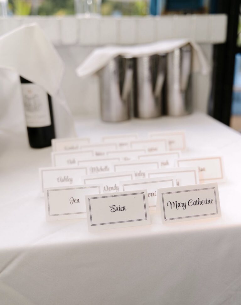 Handwritten-style place cards for the Supper Club guests lined up on a white table at Kyma